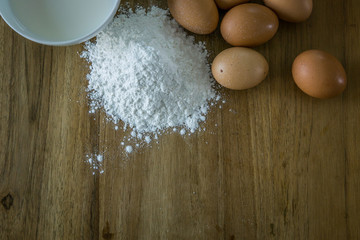 egg,flour,milk on wood table.