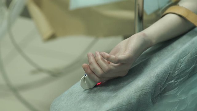 the patient's hand with a heart rate monitor