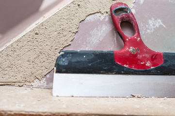 Repairing fireplace surface with spackle and trowel by hand