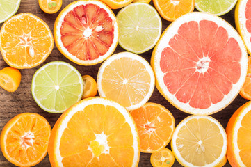 Fototapeta na wymiar Colorful fresh citrus fruit on wooden background. Orange, tangerine, lime, blood orange, grapefruit. Fruit background. Summer food concept. Flat lay, top view, copy space