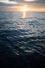 ocean wave splitted by waterline to sunset view