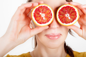 Healthy eating concept. Joyful happy young woman holding juicy oranges before her eyes. Isolated over white.