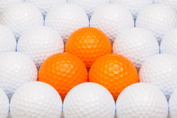 White and orange golf balls in the box