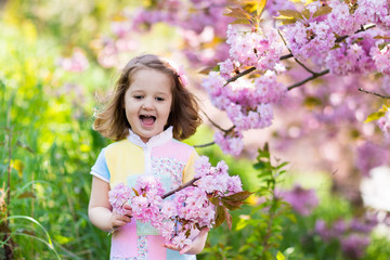 Fototapeta premium Little girl with cherry blossom