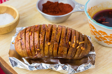 Prepared for oven hasselback potatoes with smoked paprika and bacon.