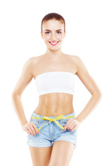 Obraz premium Fit, healthy and sporty woman in denim shorts isolated on white. Beautiful girl measuring her body.