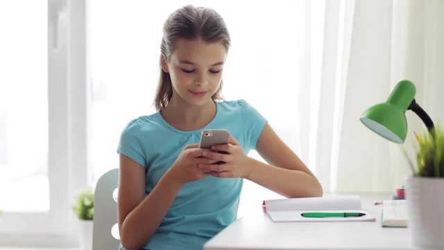 girl with smartphone distracting from homework
