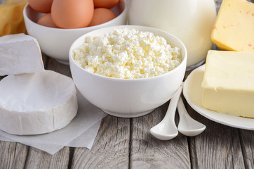 Fresh dairy products. Milk, cheese, brie, Camembert, butter, yogurt, cottage cheese and eggs on wooden table.