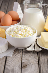 Fresh dairy products. Milk, cheese, brie, Camembert, butter, yogurt, cottage cheese and eggs on wooden table.