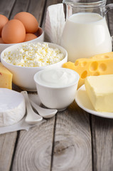 Fresh dairy products. Milk, cheese, brie, Camembert, butter, yogurt, cottage cheese and eggs on wooden table.