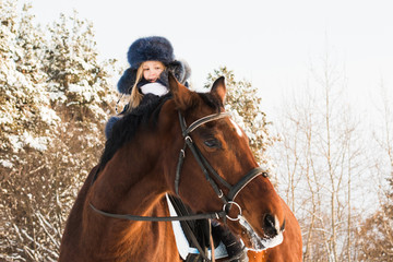 Fototapeta premium Small girl and horse in a winter