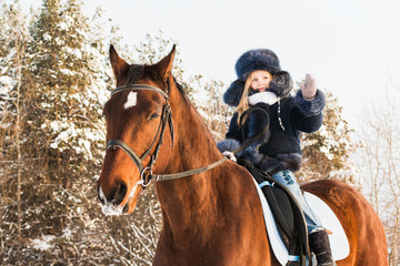 Fototapeta premium Small girl and horse in a winter