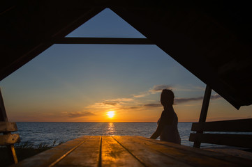 Female silhouette on sunset at sea