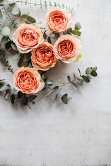 orange roses and decorative branches on white textured backgroun