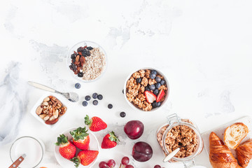 Healthy breakfast with muesli, fruits, berries, nuts on white background. Flat lay, top view