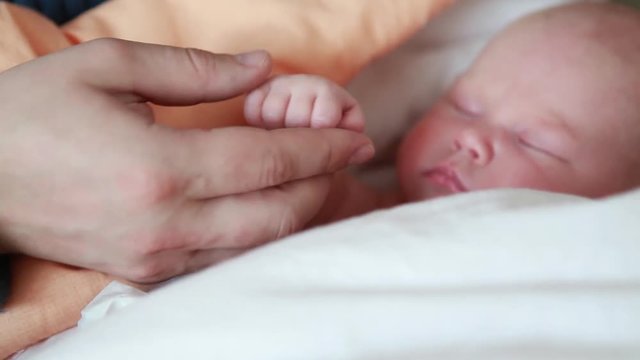 Hands of the baby in hands of parents