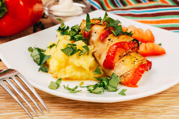 Куриное филе, запеченное с перцем, и картофельное пюре на тарелке