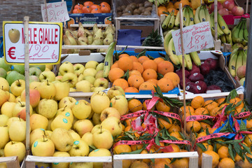 Frutta esposta con i prezzi su cartellini di carta scritti a mano