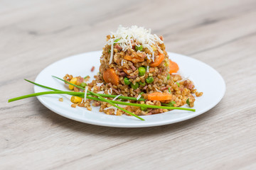 Bulgur vegetable salad with goat cheese on wooden table