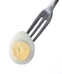 Boiled quail egg on a fork isolated against white