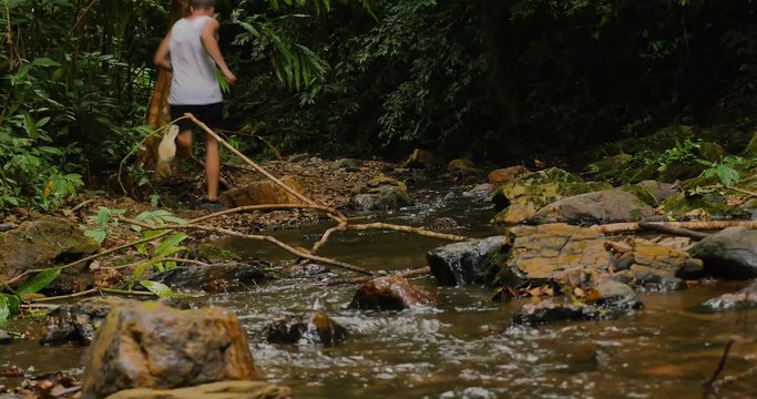 Man running in the jungle next to a river