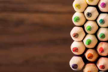 Tips of coloring pencils over a brown textured background. shallow depth of field.