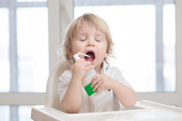 Baby getting medicine through oral spray