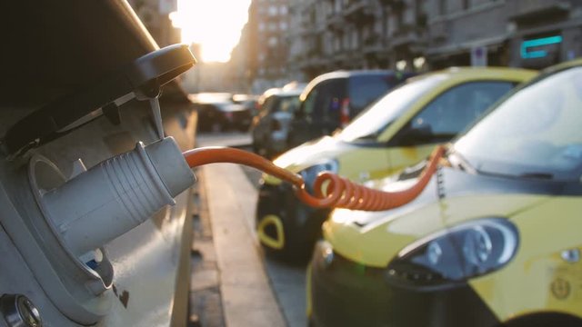 Small yellow electro cars is charging in the street station. Close-up.