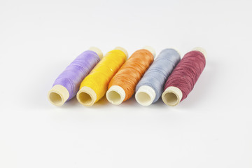 
Coloured bobbins of thread on white background 
