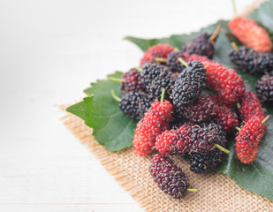 Mulberry with leaf on white wood background