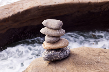 Balanced stack of stones on a rock with water