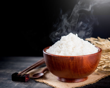 Cooked rice with smoke in wooden bowl,dark background