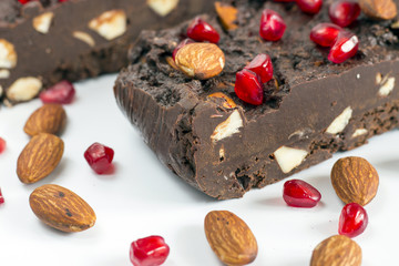Homemade nut fudge with almond and pomegranate seeds on white background