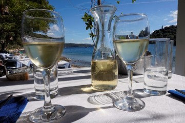 white wine decanter and glases on beach