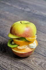 Creative healthy  apple burger filled with sliced fresh tropical fruits.Healthy eating concept