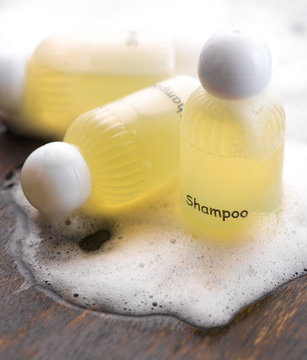 Shampoo bottle with soap on wood