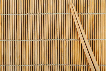Bamboo sushi mat and chopsticks on top