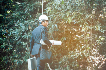 forman engineer hand holding mobile phone and working area forest