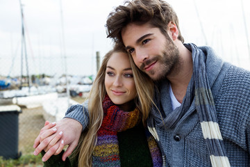 Beautiful young couple in love in a cold winter on the beach.