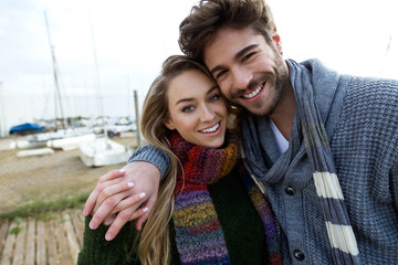 Beautiful young couple in love in a cold winter on the beach.