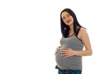 pretty pregnant woman with already big belly posing in studio on white background isolated