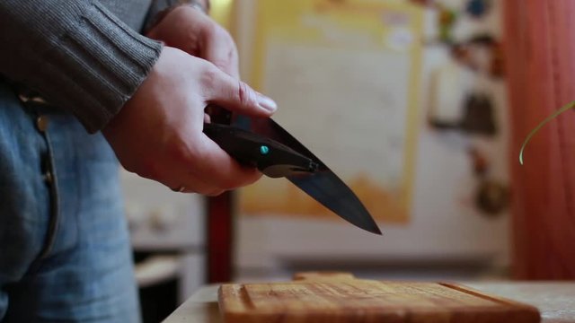 Man sharpening the knife in the kitchen