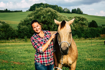 Girl with a blue and red mapped shirt with a horse in Slovakia