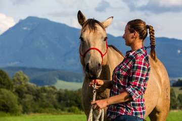 Girl with a blue and red mapped shirt with a horse in Slovakia