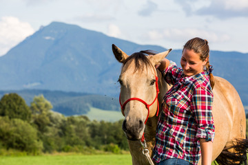 Girl with a blue and red mapped shirt with a horse in Slovakia