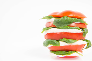 Caprese salad - tomato with mozzarella and basil on a white background