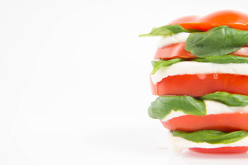 Caprese salad - tomato with mozzarella and basil on a white background