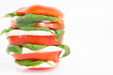 Caprese salad - tomato with mozzarella and basil on a white background