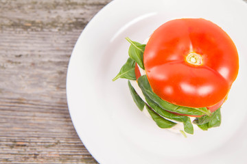 Caprese salad - tomato with mozzarella and basil on a wooden background