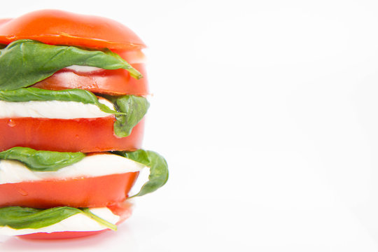Caprese salad - tomato with mozzarella and basil on a white background